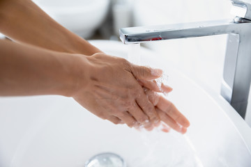 Close up woman cleans hands wash away dirt under running water from tap. Due to 2019-ncov corona virus outbreak, handwashing important part of personal hygiene, Stop ncov, keep your arms clean concept