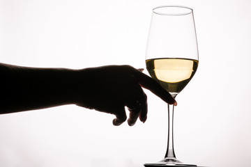 Female hand touching glass with white wine toasting isolated on a white background