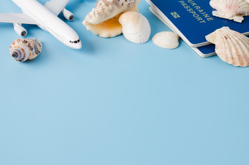 Summer travel concept. Decorative airplane, passports, hat and seashells.