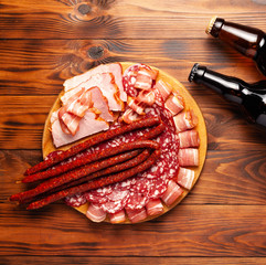 Beer snack in the form of meat products and bottled beer. Appetizer in the form of slicing bacon,...
