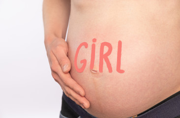 Belly of a pregnant woman with the words "girl"