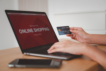 Hands holding credit card and use for shopping payment online on laptop, shopping online concept.
