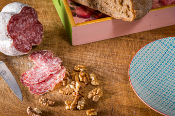 Pause mit Brotzeit in der Küche. Salami, Nüsse, Brot.