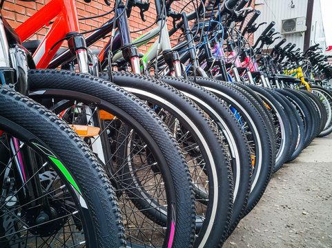 Bicycles stand in a row. Wheels close-up.