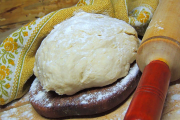 dough, rolling pin and spikelets of wheat