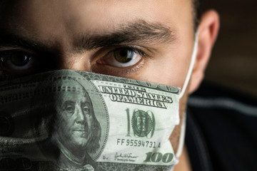 man in a medical mask of money, the concept of earnings on an epidemic, pandemic, deficiency