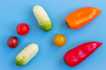 Set fresh vegetables, cucumber, tomatoes, peppers on a blue background.  Healthy food concept. Flat lay, top view.