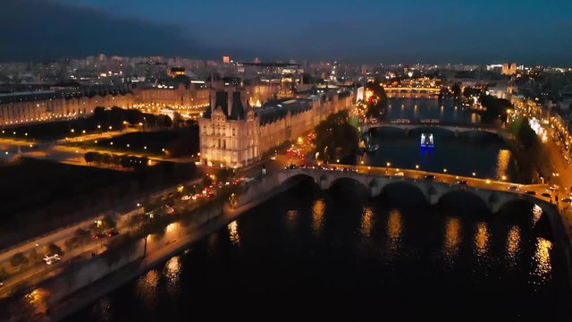 Aerial drone reveal shot  of Louvre Museum and Seine River Paris night cityscape