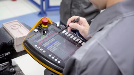 Worker uses touch control panel. Scene. Skilled worker uses electronic control panel in modern enterprise. Close-up of worker setting tasks on electronic control panel