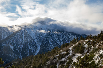 Fototapeta premium clouds covering snowy mountain top