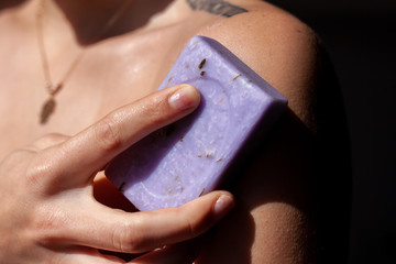 A portrait of young woman with a bar of soap in a studio, beauty and skin care.