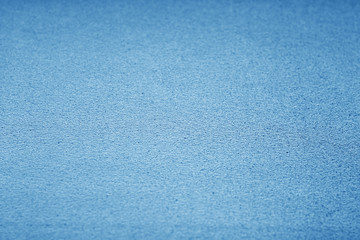 Plastic glittering texture with blur effect in navy blue tone.