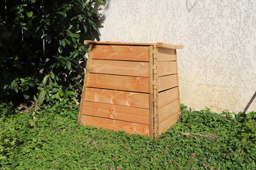 Composteur en bois posé sur l'herbe pour la fabrication de compost
