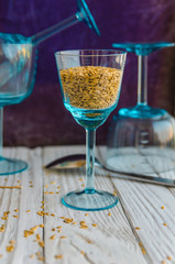 Flax seeds on the background of old cutlery and glass goblets.