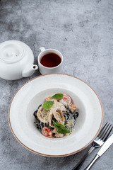 Black ink pasta with prawns, squid and creamy parmesan sauce