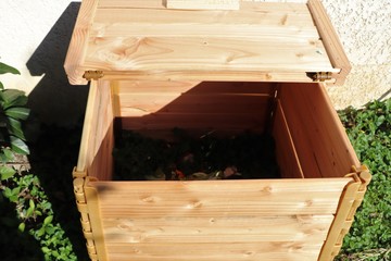 Composteur en bois posé sur l'herbe pour la fabrication de compost