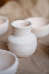 dishes made of white clay without glaze after firing on a brown background close-up. pottery