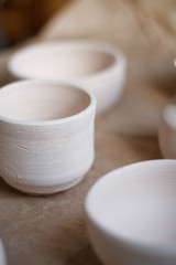dishes made of white clay without glaze after firing on a brown background close-up. pottery