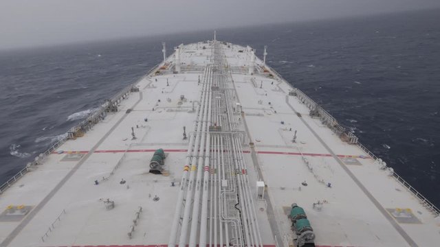  Large tanker ship rolls on waves in ocean in cloudy day