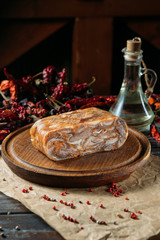 Large piece of traditional dish head cheese on wooden cutting board on craft paper.