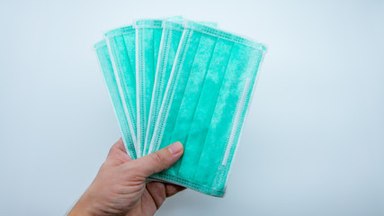 Close-up of green medical mask on a white background. A disposable masks