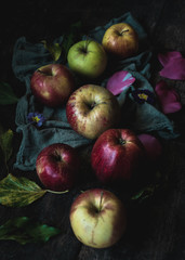 Colorful apples on the rustic wooden table.Dark mood concept light.
