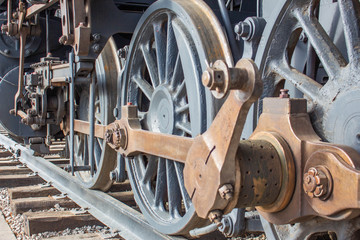 The old iron railway steam locomotive wheels and rods closeup detail