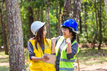 The engineering team is proud of its success. Young Engineer female holding tablet on hand. Engineer team working on project at the forest. Electricians carpenter or technical operaters and labourer.