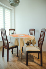 Eating area in home. Dining table and four chairs closeup. Concept of cozy family meal.