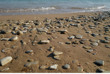 Small stones sand and sea wave.