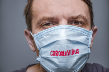 Coronavirus COVID-19. Pandemic background. Face of tired man in medical mask and gloves. Despaired male and new confirmed cases of coronavirus disease COVID-19. Negative emotions Facial expression