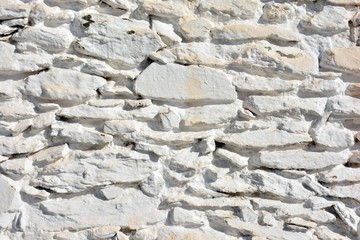 Textura de un muro hecho con piedras pintadas de blanco en la Alpujarra de Granada, España