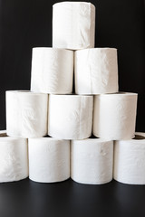 Pyramid of toilet paper on black background