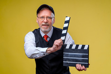 Senior man holds film flap close up. Film directing. Film production. Human emotions.