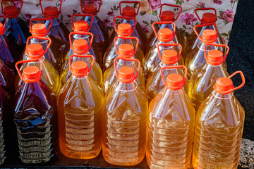 Plastic bottles with freshly squeezed white grape juice during a food and wine street food festival