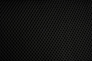 Black background with holes in a textured fabric