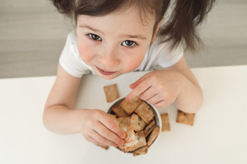 Children eat gluten cookies. A baby eats delicious pastries. Baby handles grab a cookie