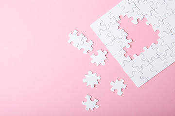 White puzzle on a colored background top view.