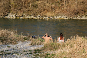 Erstes Sonnenbad mit Partnerin am Flussufer zum Früjahr