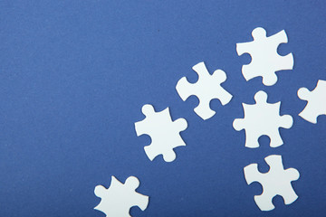 White puzzle on a colored background top view.
