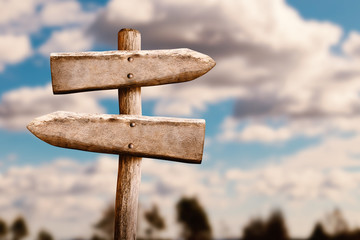 Weathered Wood Signboard - Old Wooden Signpost with Clouds on Sky on Background.