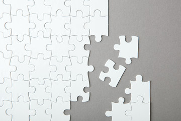 White puzzle on a colored background top view.