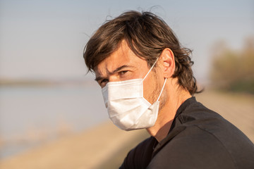 Handsome man wore face mask preventing himself from the corona outbreak in his society.