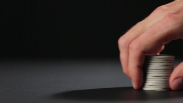 Male hand with chips for gambling games on dark background
