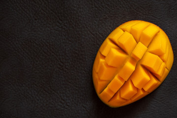 Mango Kent from Peru with delivery. Juicy slice on a dark background.