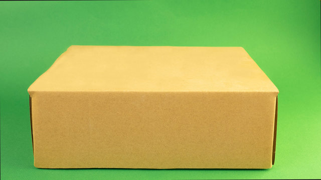a cardboard box is lying on a green background