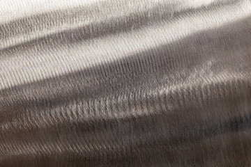 Close-up texture of flat steel surface manually cleaned with a flap wheel angle grinder.