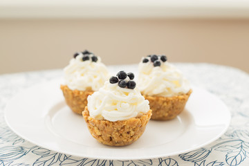 Homemade muffins with blueberries, cream and fresh berries on a napkin