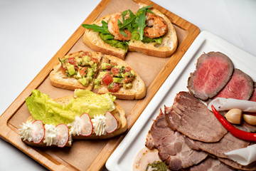 a buffet. bruschetta sandwich meat and vegetables.