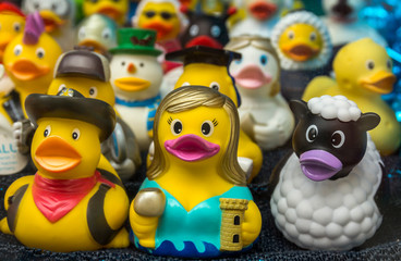 Collection of various rubber ducks in a shop window of a souvenir store.